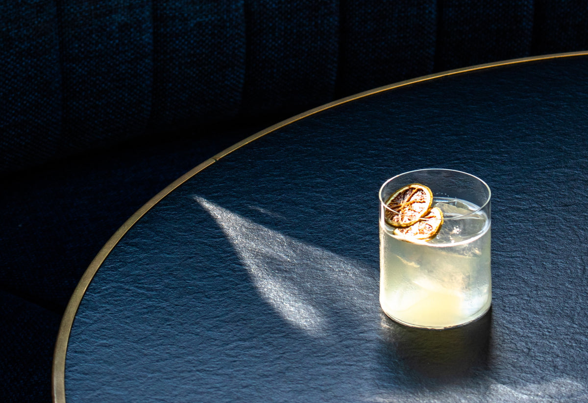Craft cocktail with a dried citrus wheel garnish in a rocks glass